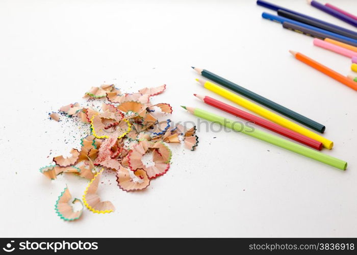 Colorful pencil crayons on white desktop with pencil shavings