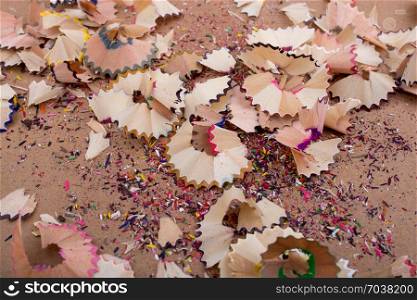 Colorful pencil shavings on a brown background
