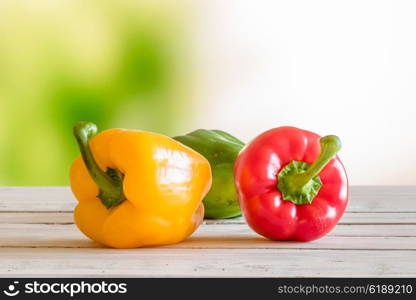 Colorful peppers on a wooden table in a garden