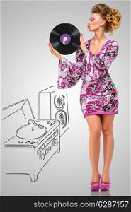 Colorful photo of a clubbing fashionable hippie homemaker sending a kiss to a retro vinyl record in her hands on grey sketchy background of a DJ mixer and acoustic system.