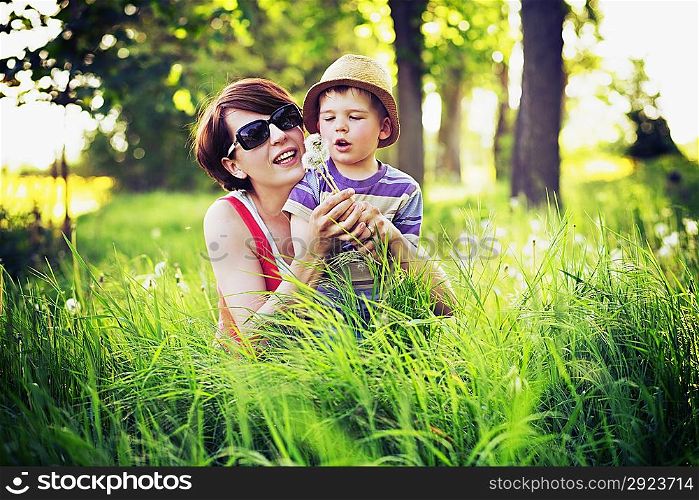 Colorful photo of mother and cute kid playing blow-balls
