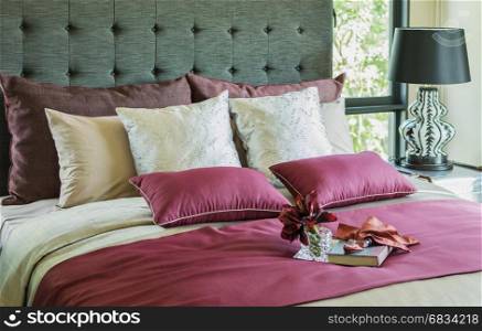 Colorful Pillow and decorative tray with book, flower on the bed