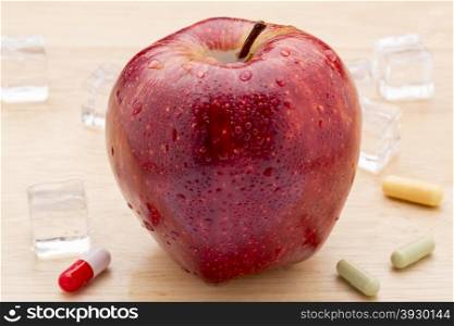 Colorful pills and red apple. Colorful pills and freshest red apple on wooden background