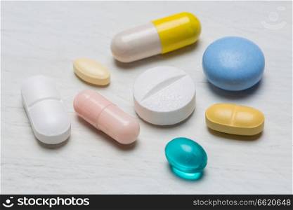 Colorful pills on white wooden background close up.. Colorful pills on white wooden background close up