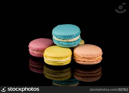 Colorful pink macaroon over a black background