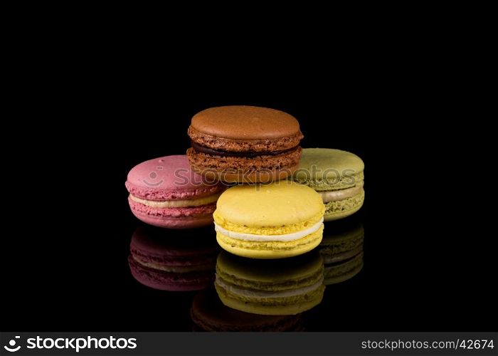 Colorful pink macaroon over a black background