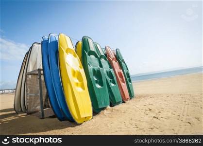 colorful plastic beach canoes on a british beach