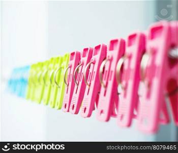Colorful plastic clothespins row hanging on a clothesline