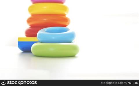 Colorful plastic rings on a white background to be stacked in a tower. Toy for newborns.