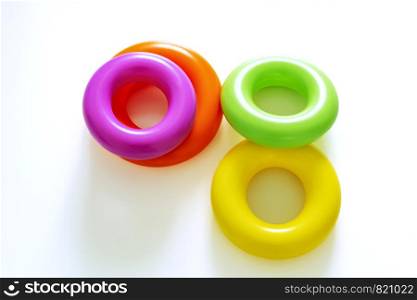 Colorful plastic rings on a white background to be stacked in a tower. Toy for newborns.