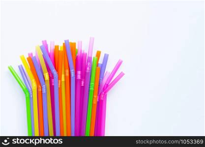 Colorful plastic straws on white background. Plastic waste pollution.