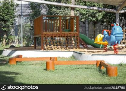 Colorful playground on yard in the park. Rocking horse, Slide and balance beam for children in public park.