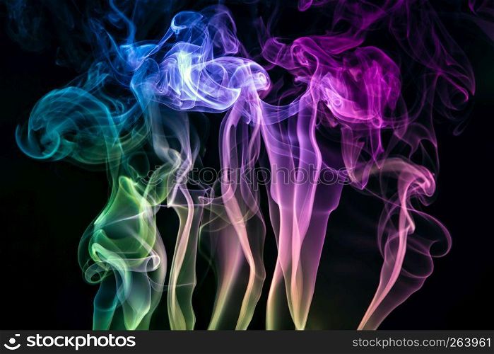Colorful purple, blue and green smoke of incence sticks isolated at black background. Colorful smoke of incence stick isolated at black background