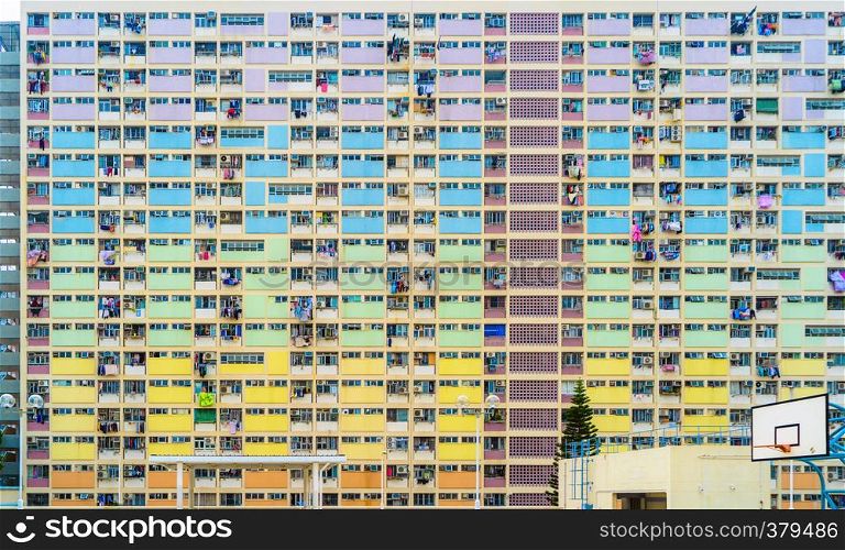 Colorful rainbow pastel building with basketball court and facade windows background. Architecture building design in Choi Hung Estate, Kowloon, Hong Kong City, China.