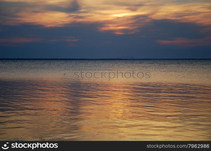 Colorful reflecting water by a cloudy sunset in the Baltic Sea