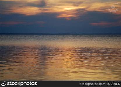 Colorful reflecting water by a cloudy sunset in the Baltic Sea