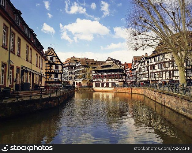 Colorful romantic city Strasbourg, France, Alsace. Traditional timbered houses near the river. Medieval home facade, historic town. Beautiful idyllic architecture reflected in water in a sunny day.