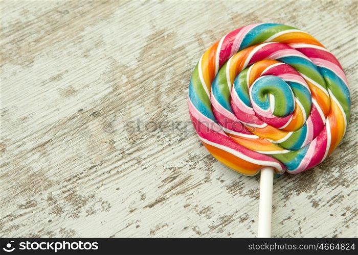Colorful round lollipop on a wooden background