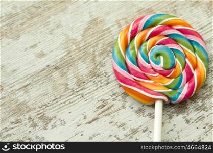 Colorful round lollipop on a wooden background