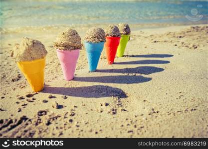 Colorful sand cones in the sand on the beach,summer concept,used split toning for vintage style.
