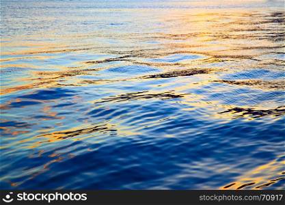 Colorful sea water surface at sundown - abstract background