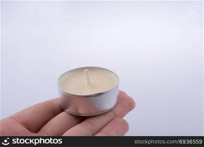 Colorful small Candle in hand on a white background