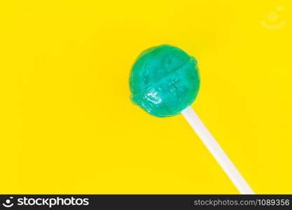 Colorful small lollipops on Yellow background