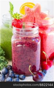 Colorful smoothy drinks in glass jars with igredients close up. Fresh smoothy drink with igredients