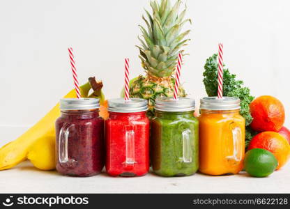 Colorful smoothy drinks in glass jars with straws and igredients. Fresh smoothy drink with igredients