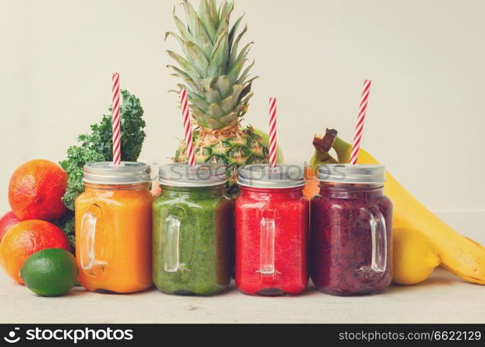 Colorful smoothy drinks in glass jars with straws and igredients, retro toned. Fresh smoothy drink with igredients