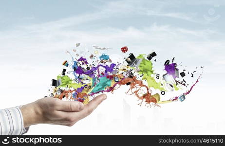 Colorful splashes in palms. Male hands with paint splashes and icons in palms