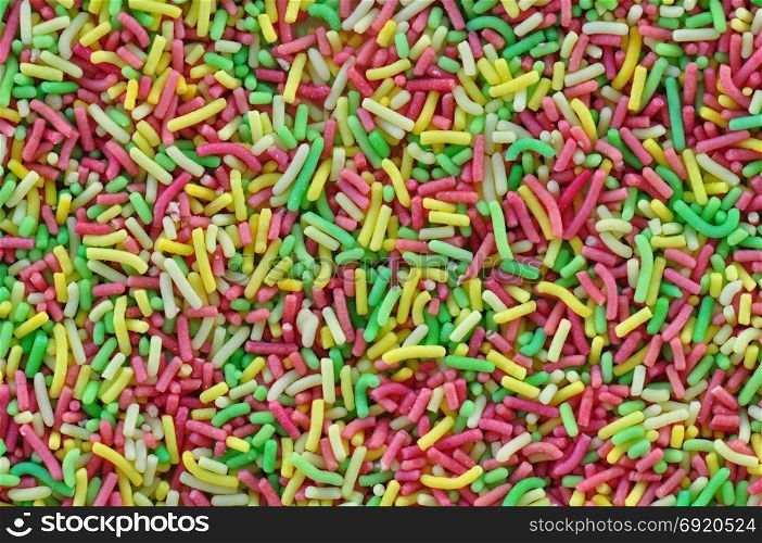 Colorful sprinkles garnish sweet candy topping abstract background.