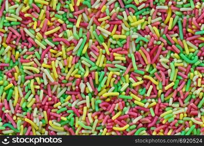 Colorful sprinkles garnish sweet candy topping abstract background.