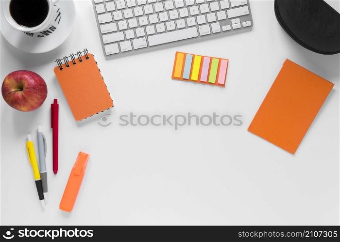 colorful stationeries with coffee cup apple keyboard white desk