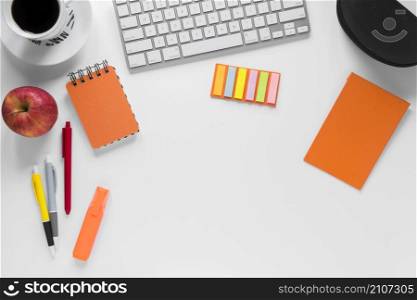 colorful stationeries with coffee cup apple keyboard white desk