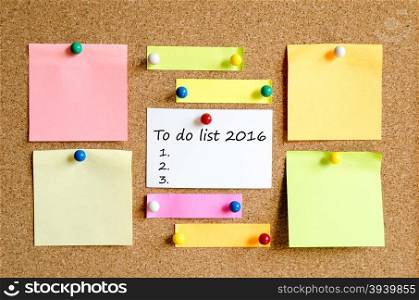 Colorful sticky notes on cork board background and text concept to do list 2016