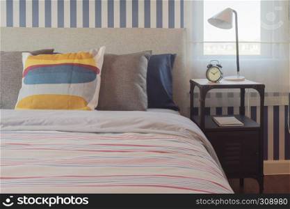 Colorful style bedding bedroom interior and clock on bedside table