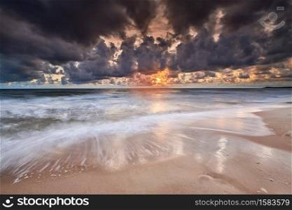 colorful sunrise on beach of baltic sea in germany