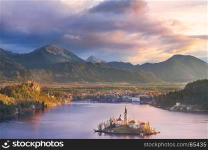 Colorful sunrise over the Bled lake, its surrounding hills, its island and the Karawanks mountains in the background, situated in Slovenia.