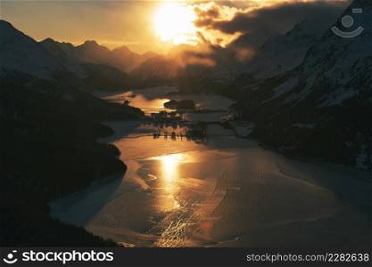 Colorful sunset over the frozen lakes of the Swiss alps at the Maloja pass near Sankt Moritz