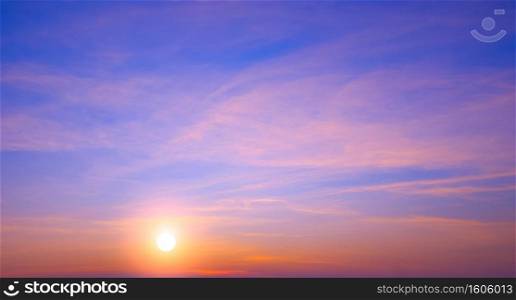 Colorful sunset sky in the evening with orange sunlight clouds on idyllic horizontal blue dusk sky background
