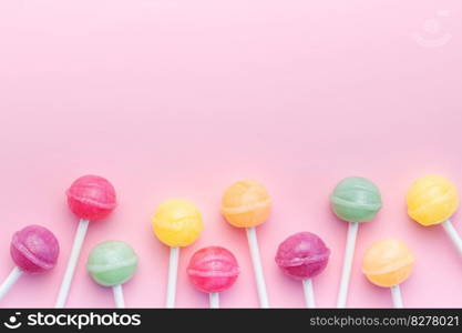 Colorful sweet lollipops over pink background.  Flat lay, top view