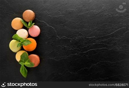 Colorful sweet macarons on a black table