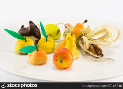 Colorful sweet marzipan fruits with cinnamon spicy stick decoration, candies dessert