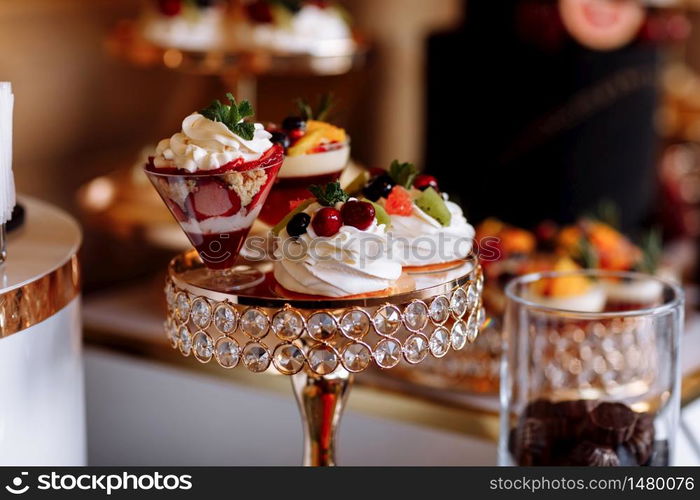 Colorful table with sweets and goodies for the wedding party reception, decoration dessert table. Delicious sweets on candy buffet. Dessert table for a party. cakes, cupcakes. Colorful table with sweets and goodies for the wedding party reception, decoration dessert table. Delicious sweets on candy buffet. Dessert table for a party. cakes, cupcakes. selective focus