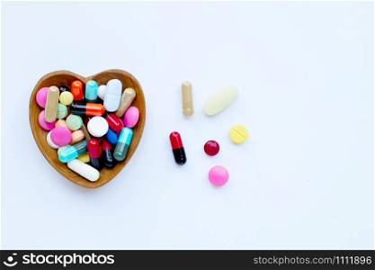 Colorful tablets with capsules and pills on white background.