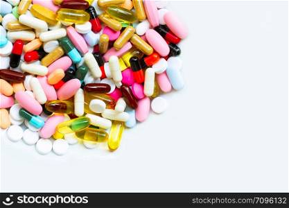 Colorful tablets with capsules and pills on white background. Copy space