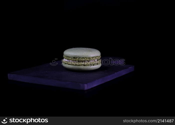 Colorful tasty macarons isolated on black background, french macarons dessert