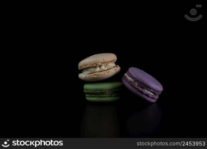 Colorful tasty macarons isolated on black background, french macarons dessert