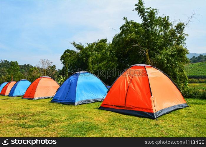 Colorful tent camping in row beautiful on green grass meadow for tourist travel relax outdoor holiday time